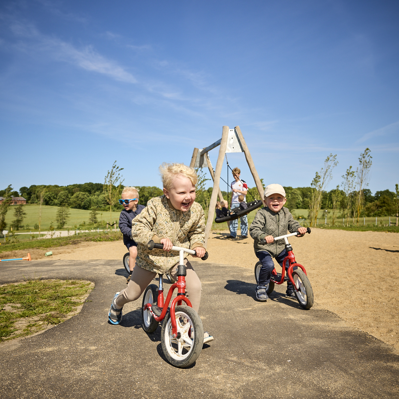 Børn cykler på legepladsen i Børnehuset Dronningborg